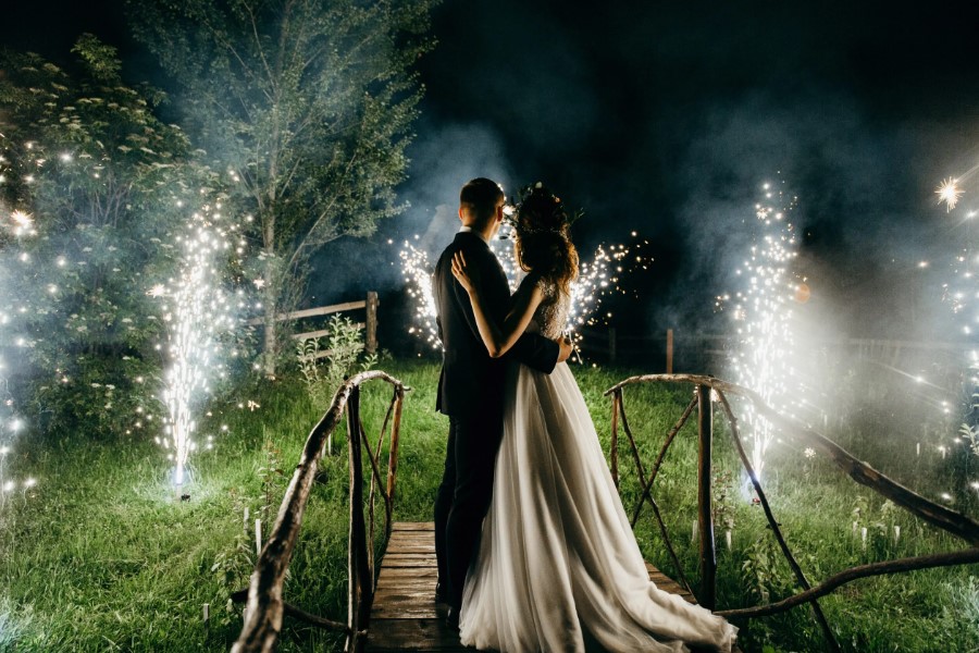 Brautpaar steht romantisch vor dem Feuerwerk