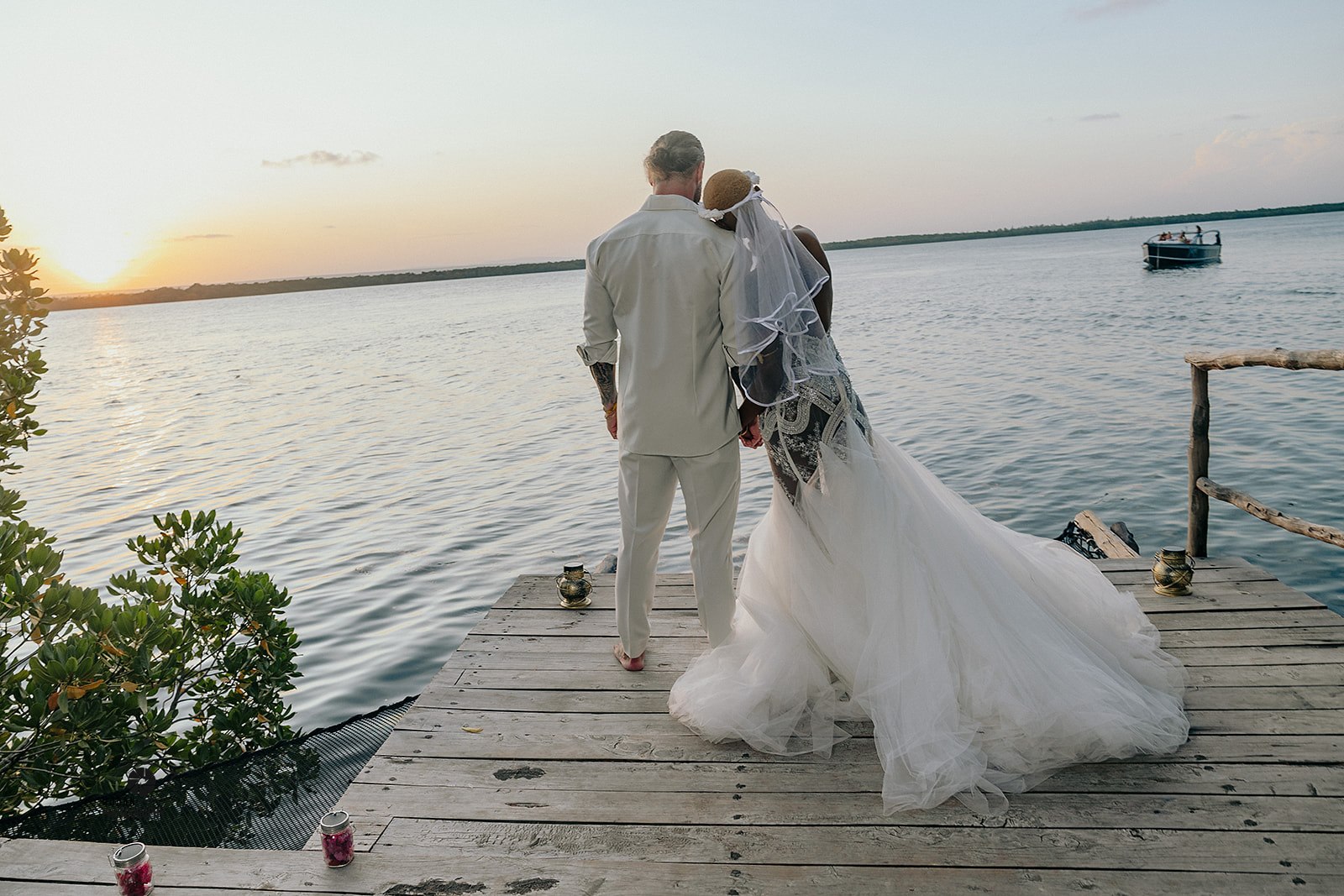 Brautpaar genießt den Sonnenuntergang auf einem Steg am Wasser während ihrer Hochzeit in Kenia – romantische Inspiration für die Hochzeitsplanung und das Heiraten in Kenia.