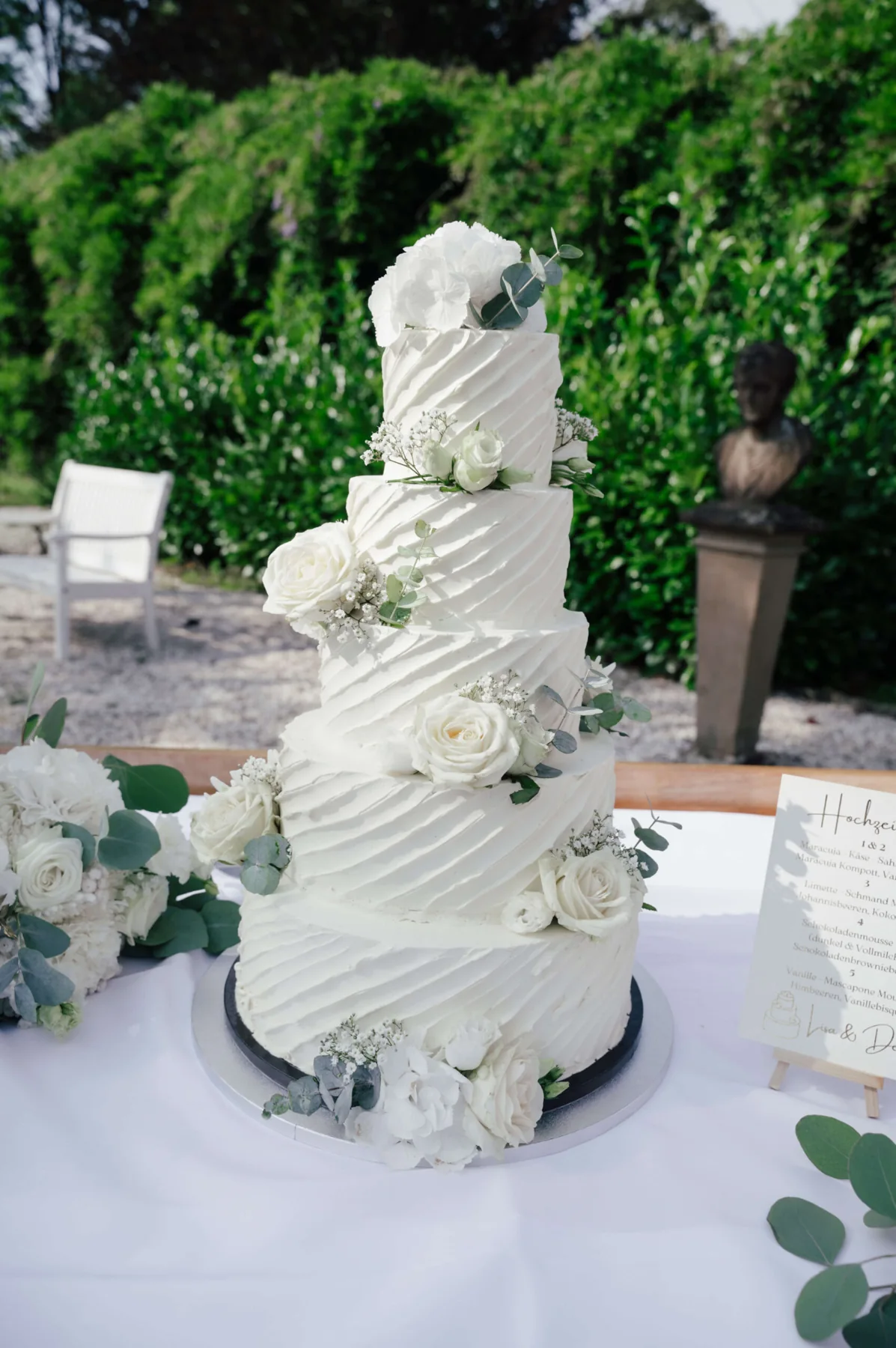 Mehrstöckige weiße Hochzeitstorte mit Blumendekoration